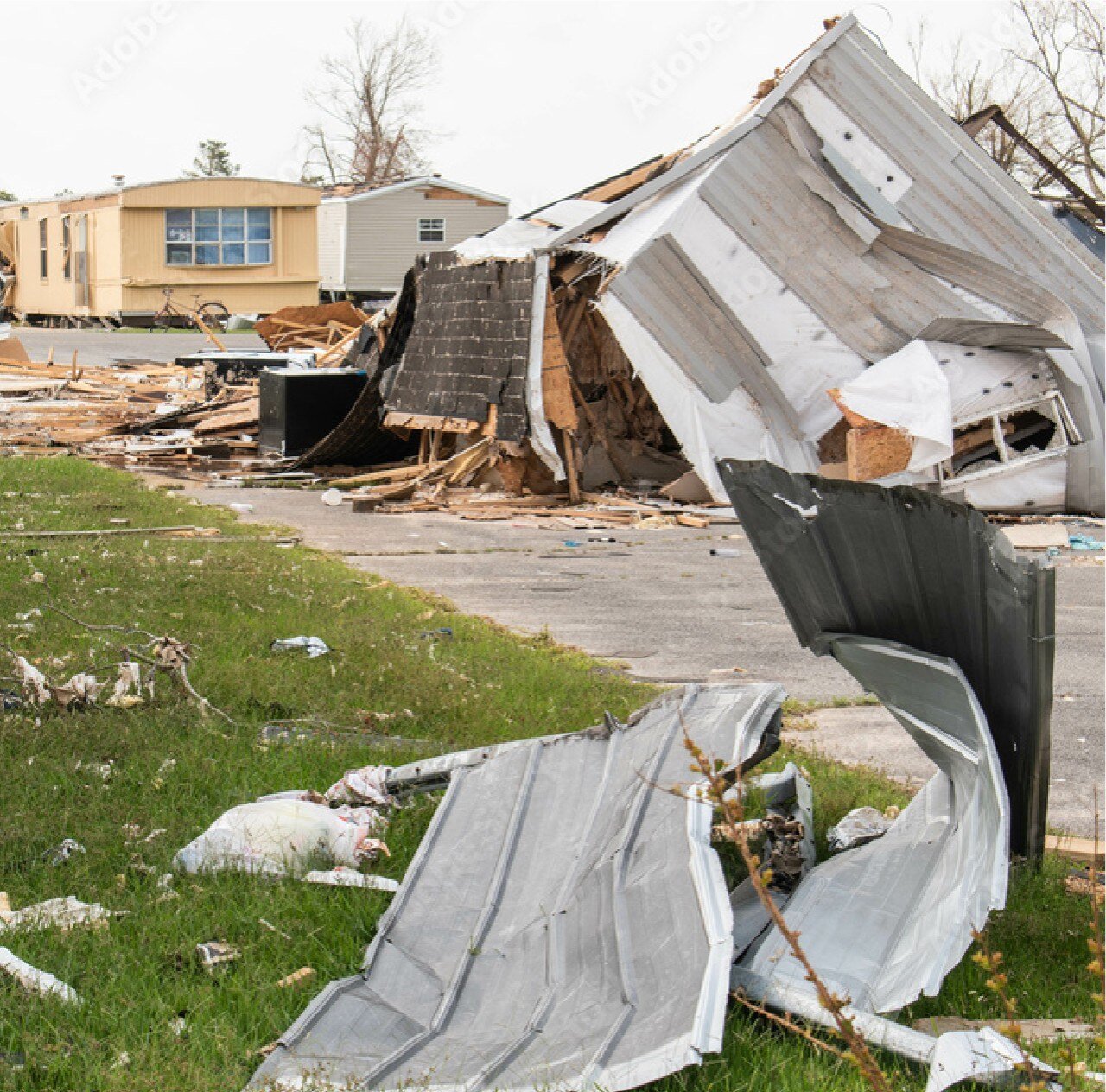 A tornado-damaged house, with debris scattered around and the structure visibly collapsed, illustrating the storm's devastation.